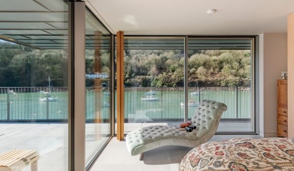 corner opening minimally framed sliding glass doors leading to a terrace by the harbor