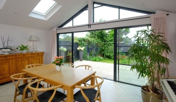 aluminium slim sliding glass doors with glazing bar for an industrial style steel look aesthetic and house plants in a modern home extension - displaying elements of biophilic design