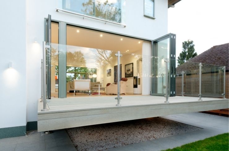 floating terrace with a glass balustrade and grey aluminium bifold door with a traffic door floating terrace with a glass balustrade and grey aluminium bifold door with a traffic door
