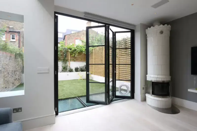three pane steel look bifold door with slim aluminium framing and applied glazing bars for an elegant and industrial aesthetic